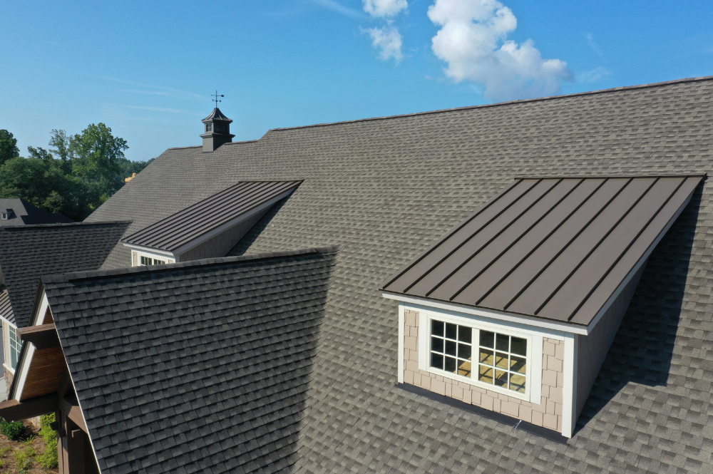 Aerial view of a residential home , showcasing a newly installed roof with clear blue skies above.